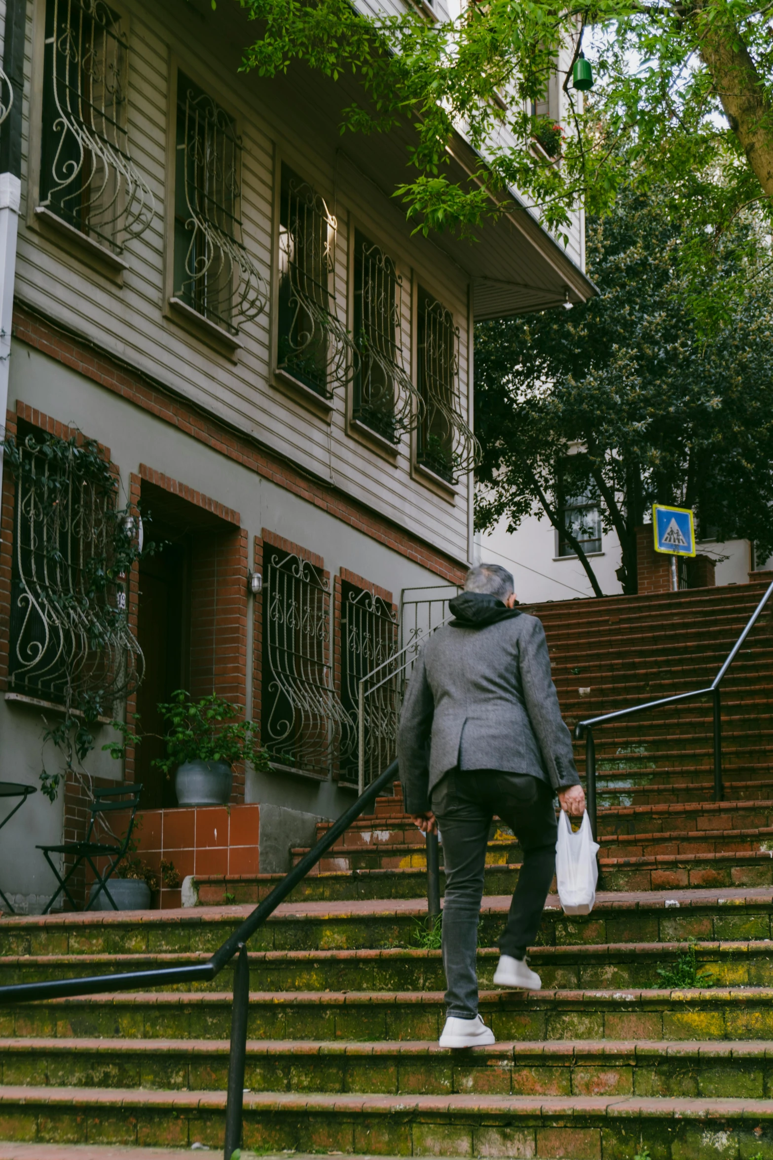 the man is coming down the stairs carrying a bag