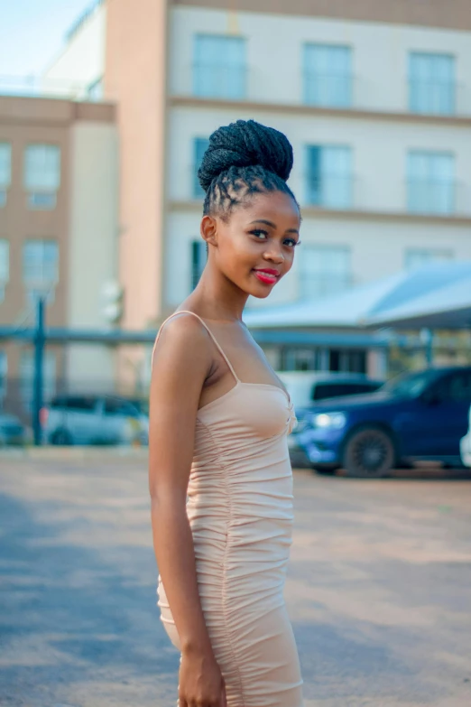 a woman in a  - colored dress posing for the camera