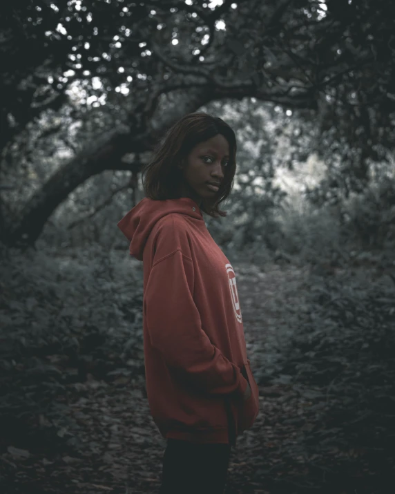 the man is in a hoodie with his face half hidden by leaves