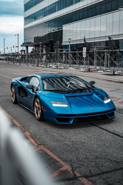 a blue sports car driving down a road