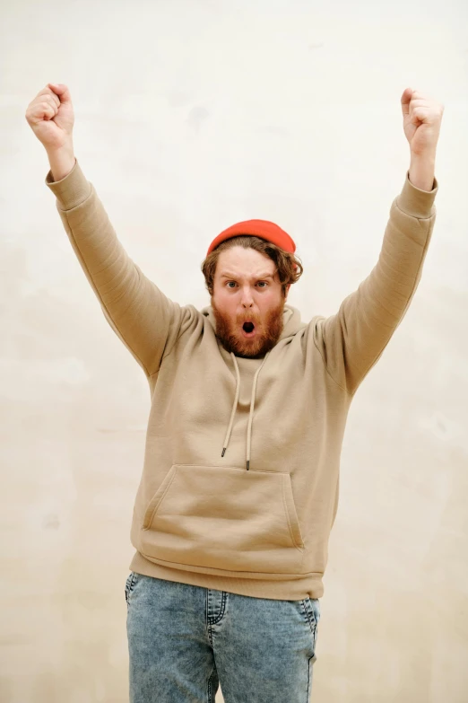 a man wearing a red hat has his arms up
