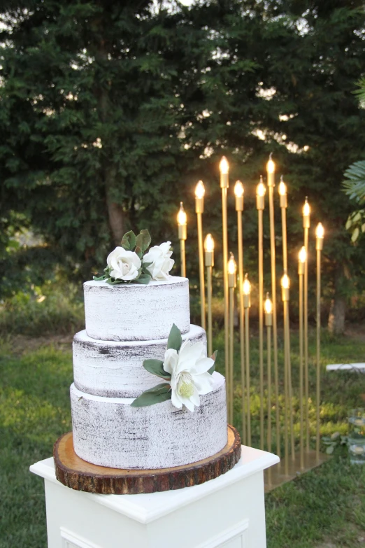 a white cake topped with flowers and lit candles