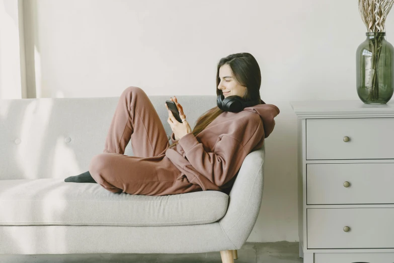 woman wearing a black hoodie on top of a couch