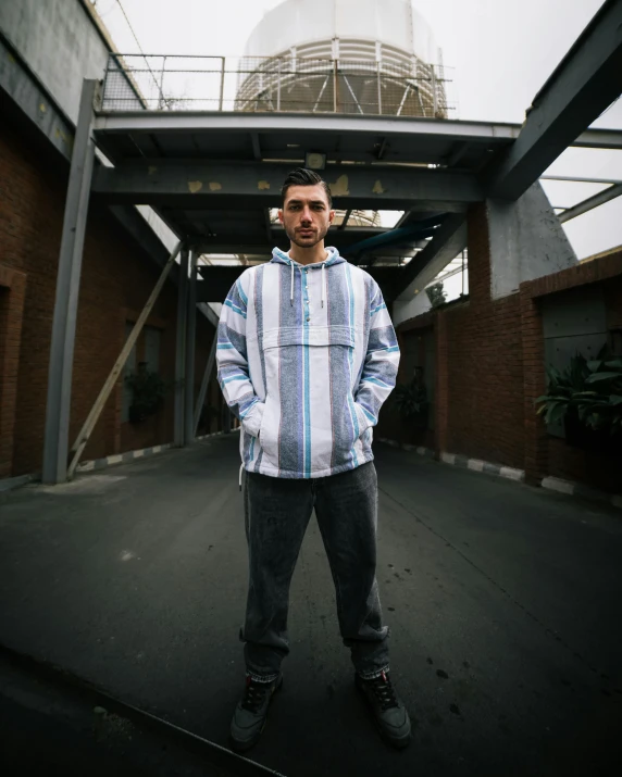 the man poses in front of an overpass