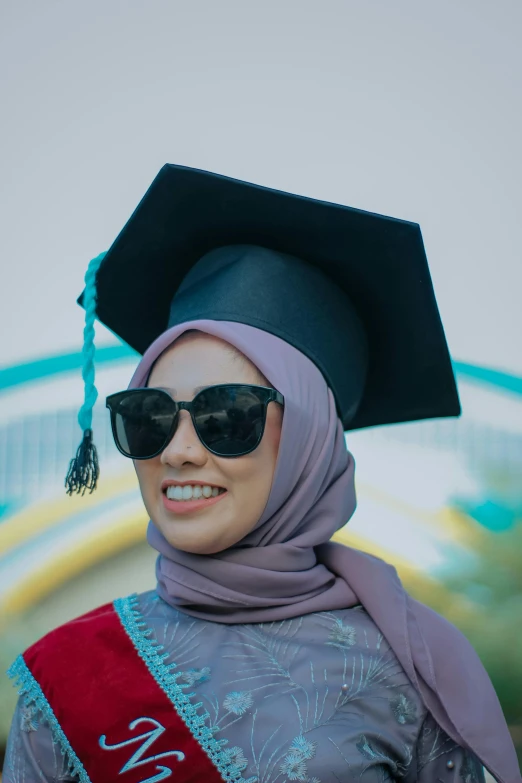 there is a woman wearing a purple graduation outfit and black sunglasses