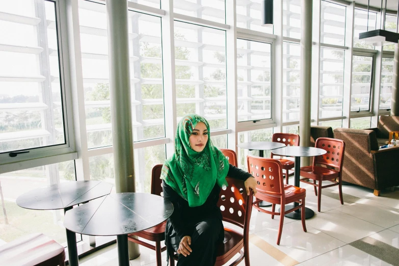 a woman is sitting in a colorful restaurant