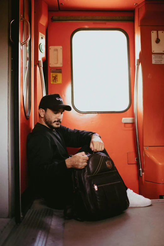 the man sitting on the bus is holding luggage