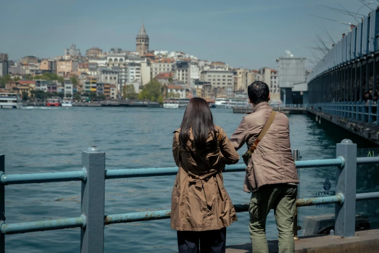 a man and woman standing on a metal dock next to water