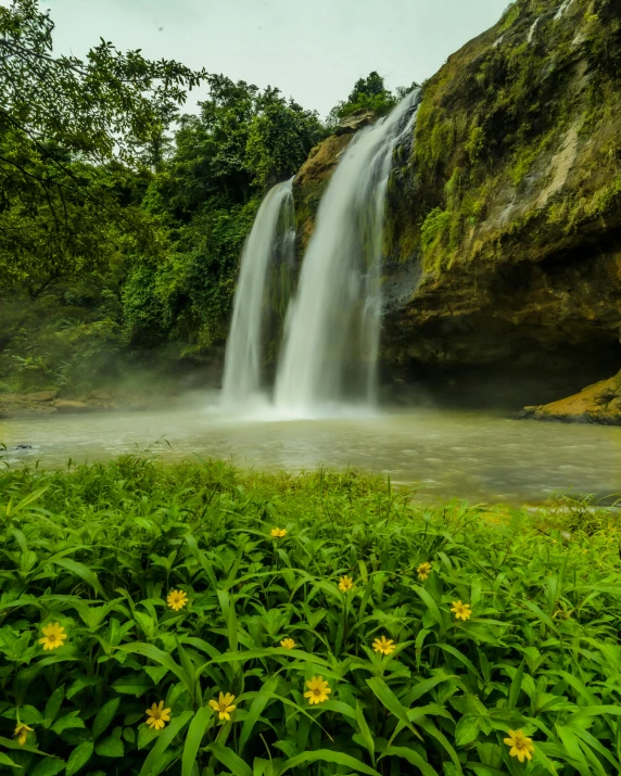 a large waterfall is towering over the water