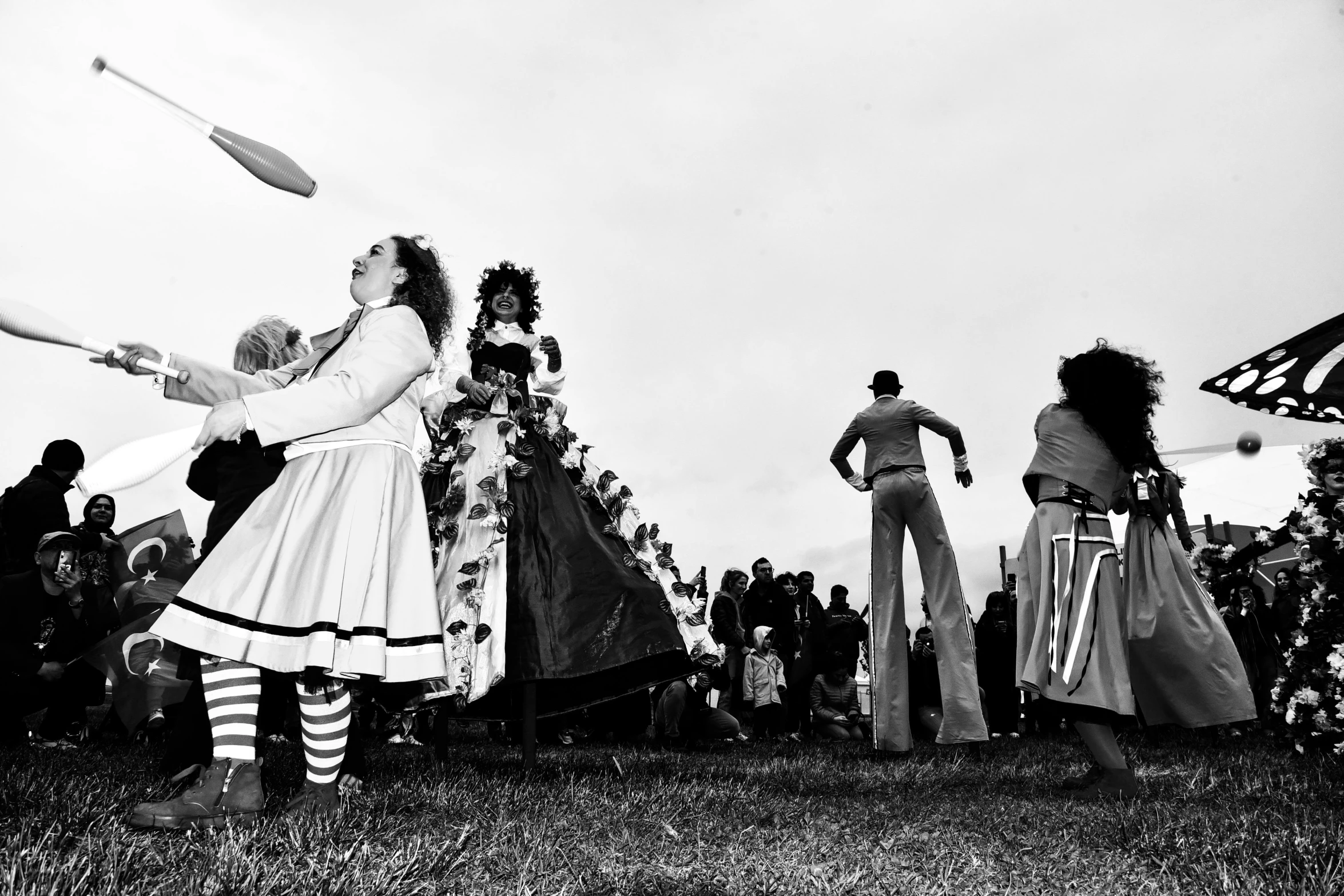 several women dressed in costume stand on the grass while holding bats