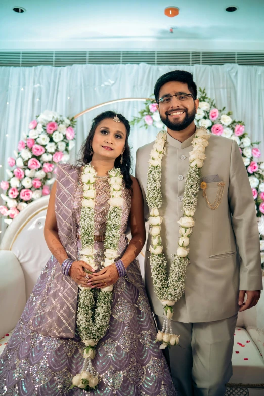 couple at their wedding ceremony standing under a floral wreath