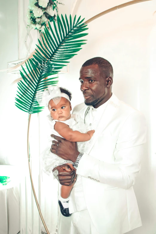 a man in a white suit holding a baby