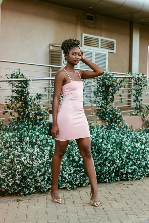 a woman in a pink dress standing outside