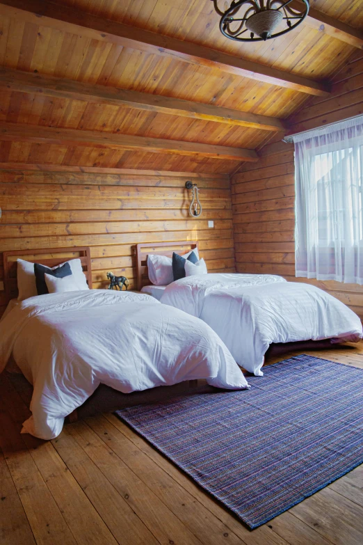 two beds sitting in a room near a window