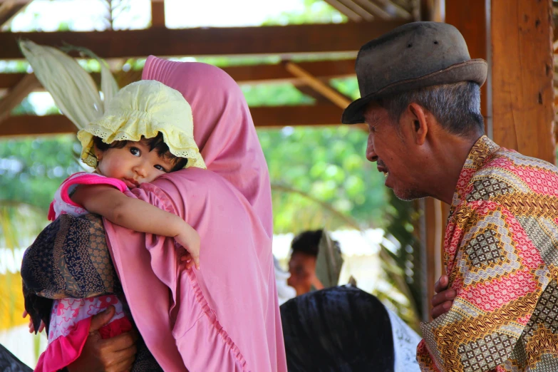 a man and woman holding a little child