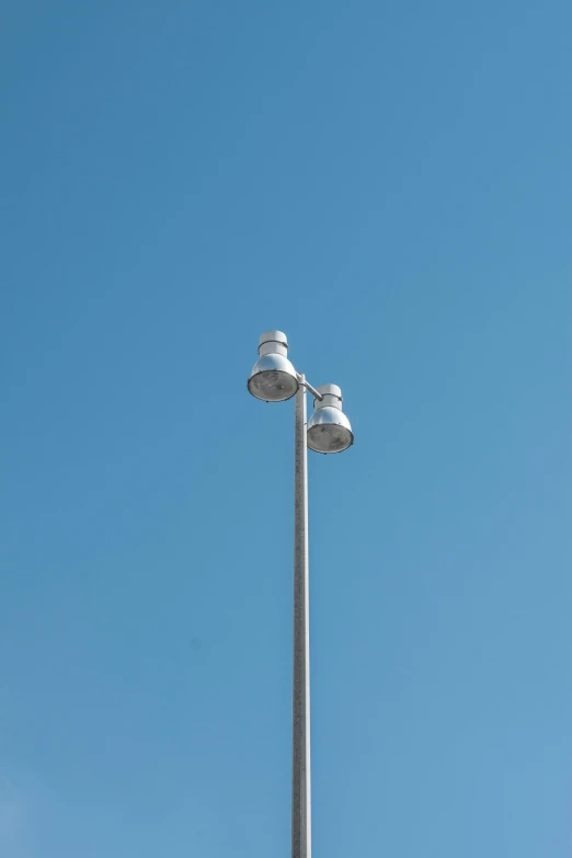 two white street lamps stand high in the sky