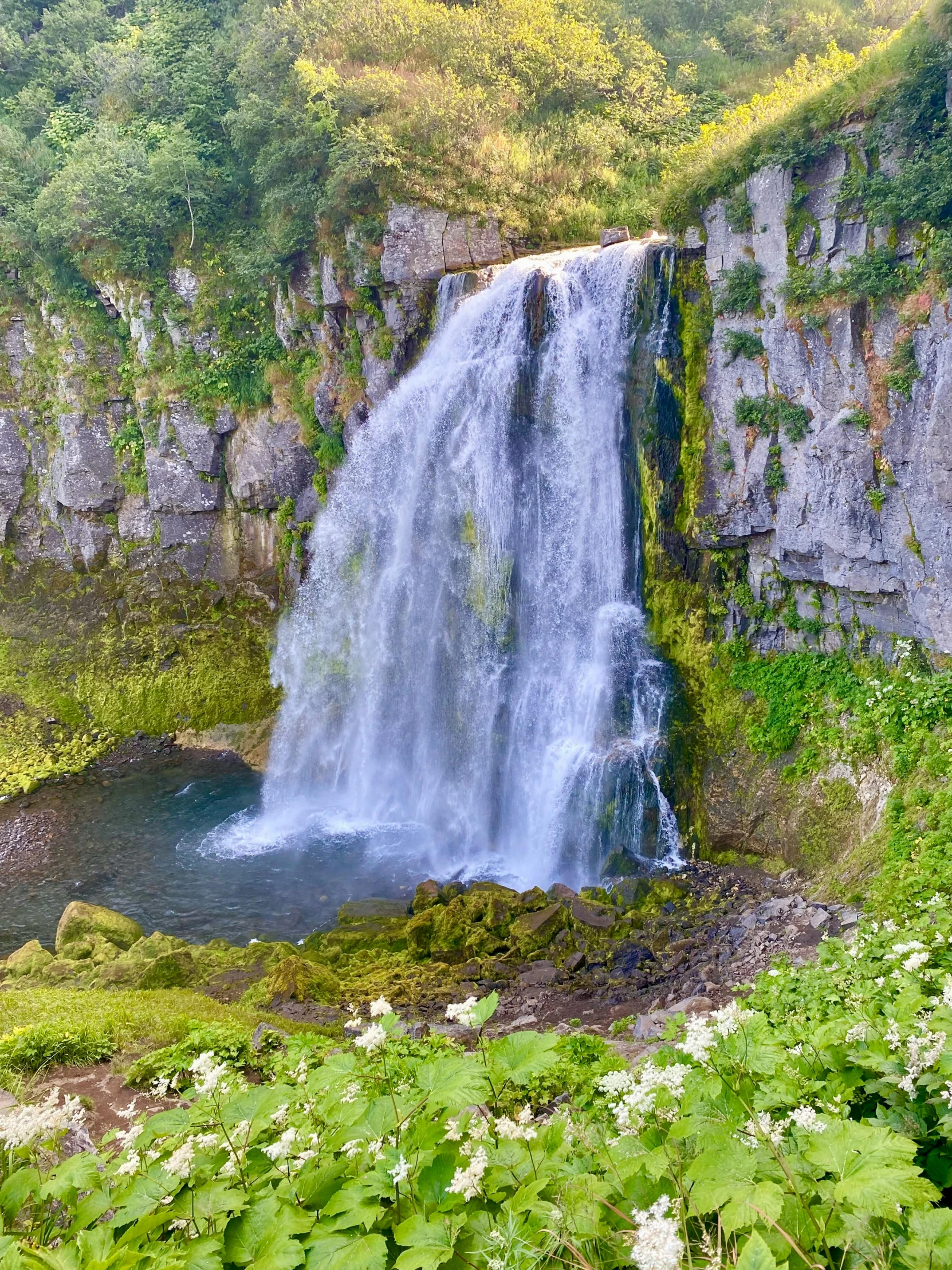 a man standing on a ledge overlooking a waterfall