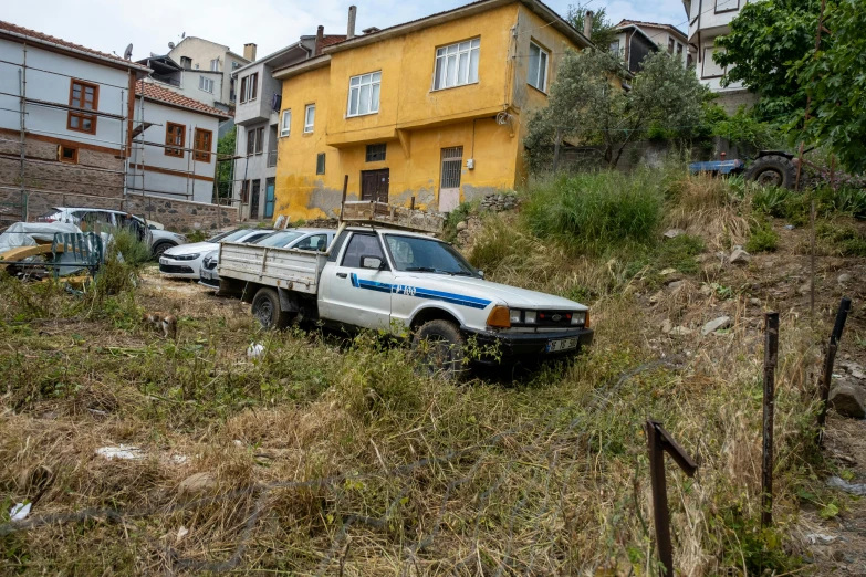 an old, white pick up truck parked in a yard