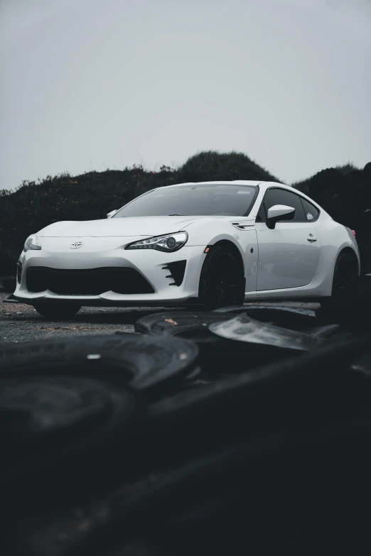 a white sports car is parked on the gravel