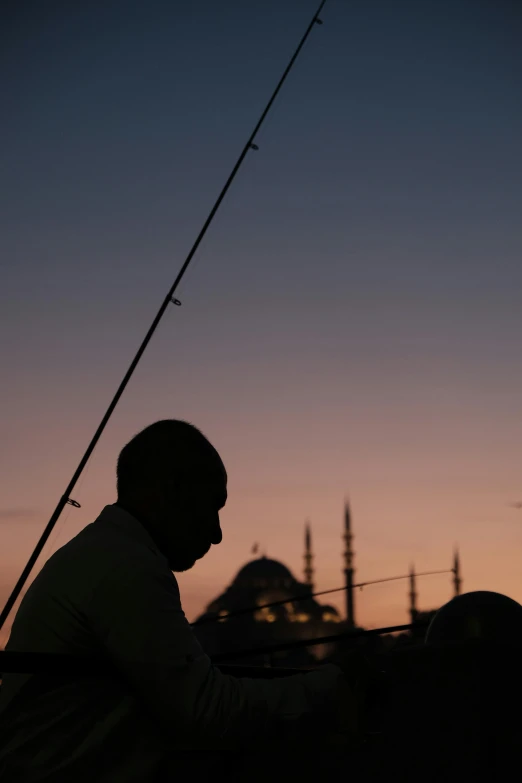 the man sits near his horse at sunset