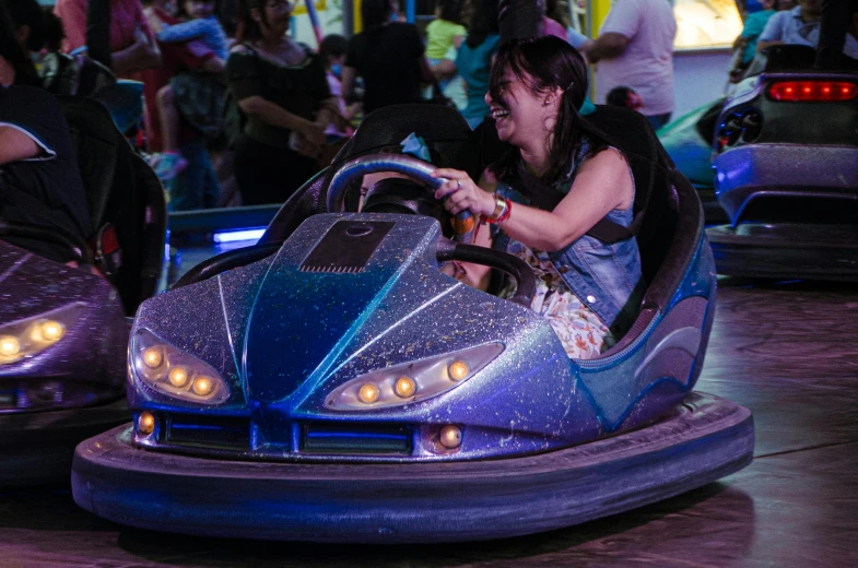 a young lady is racing a purple bumper car