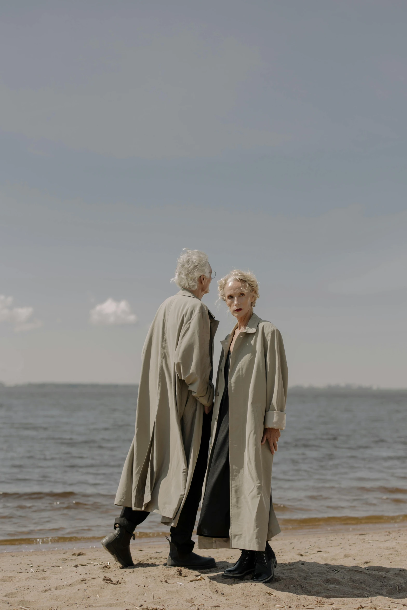 two older ladies posing for a picture on a beach