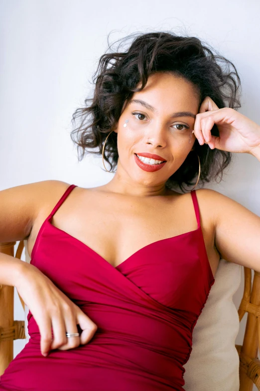 a woman in a red dress sitting on a chair