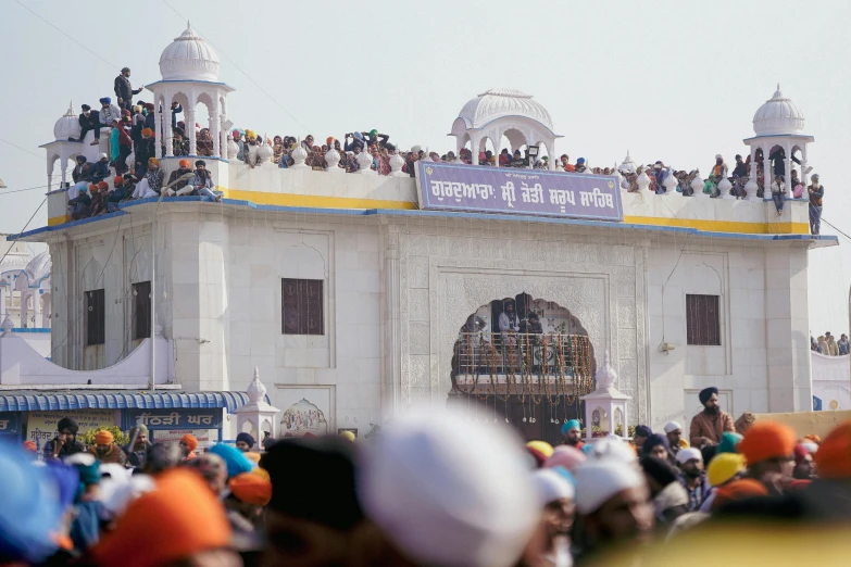 many people are lined up at the top of a building