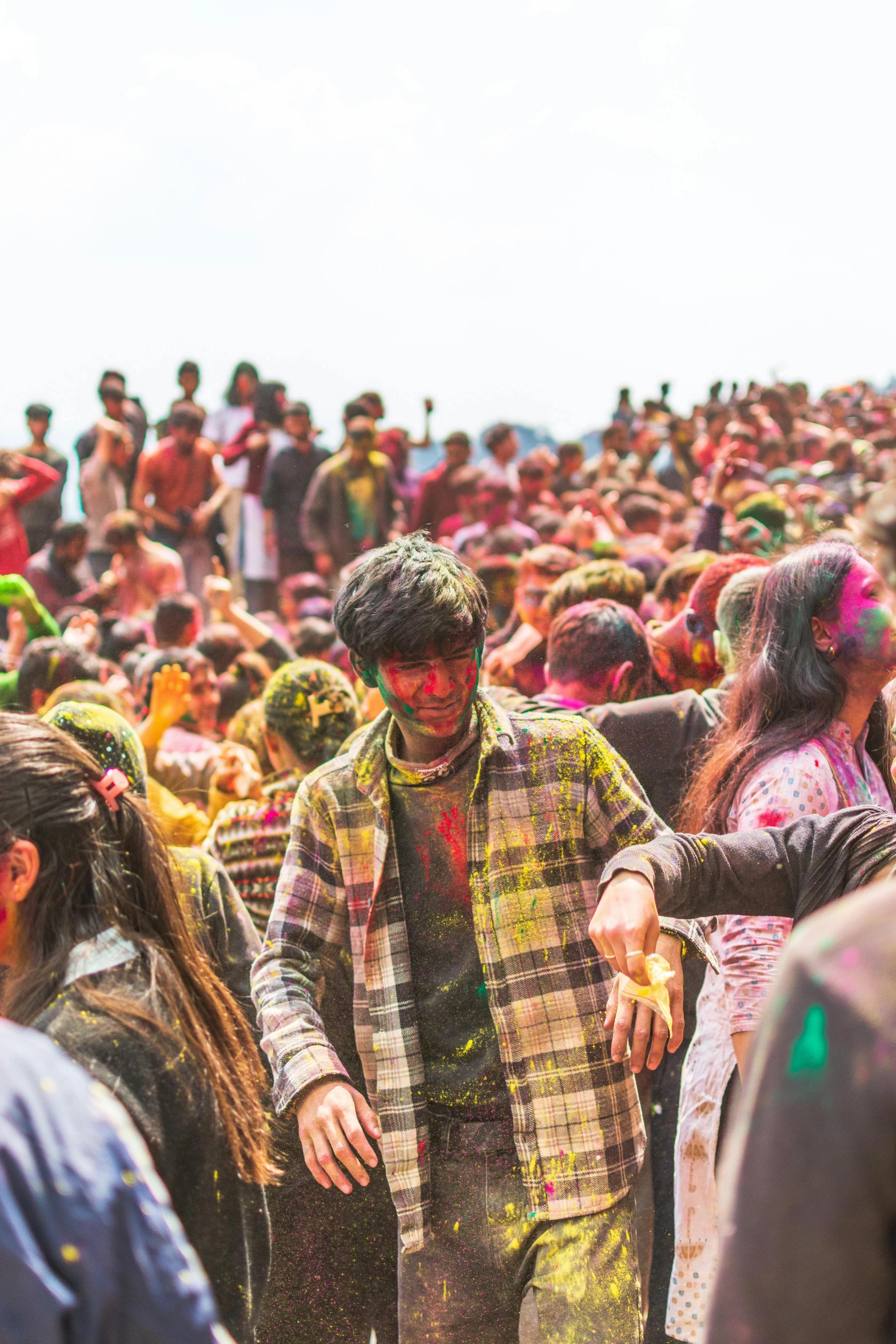 people are covered in color while a man is walking through the crowd