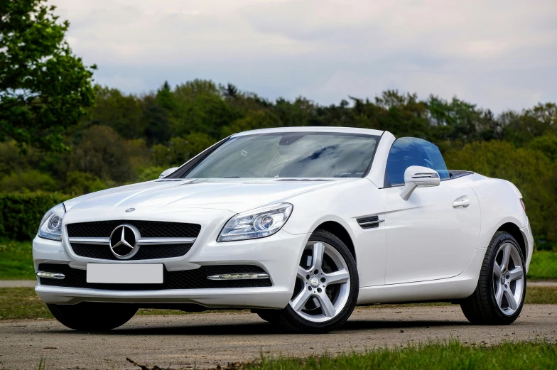 a white mercedes car sitting in a driveway