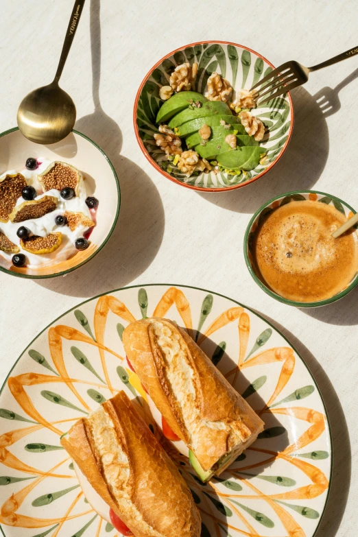 two plates with sandwiches and some bowls of cereal