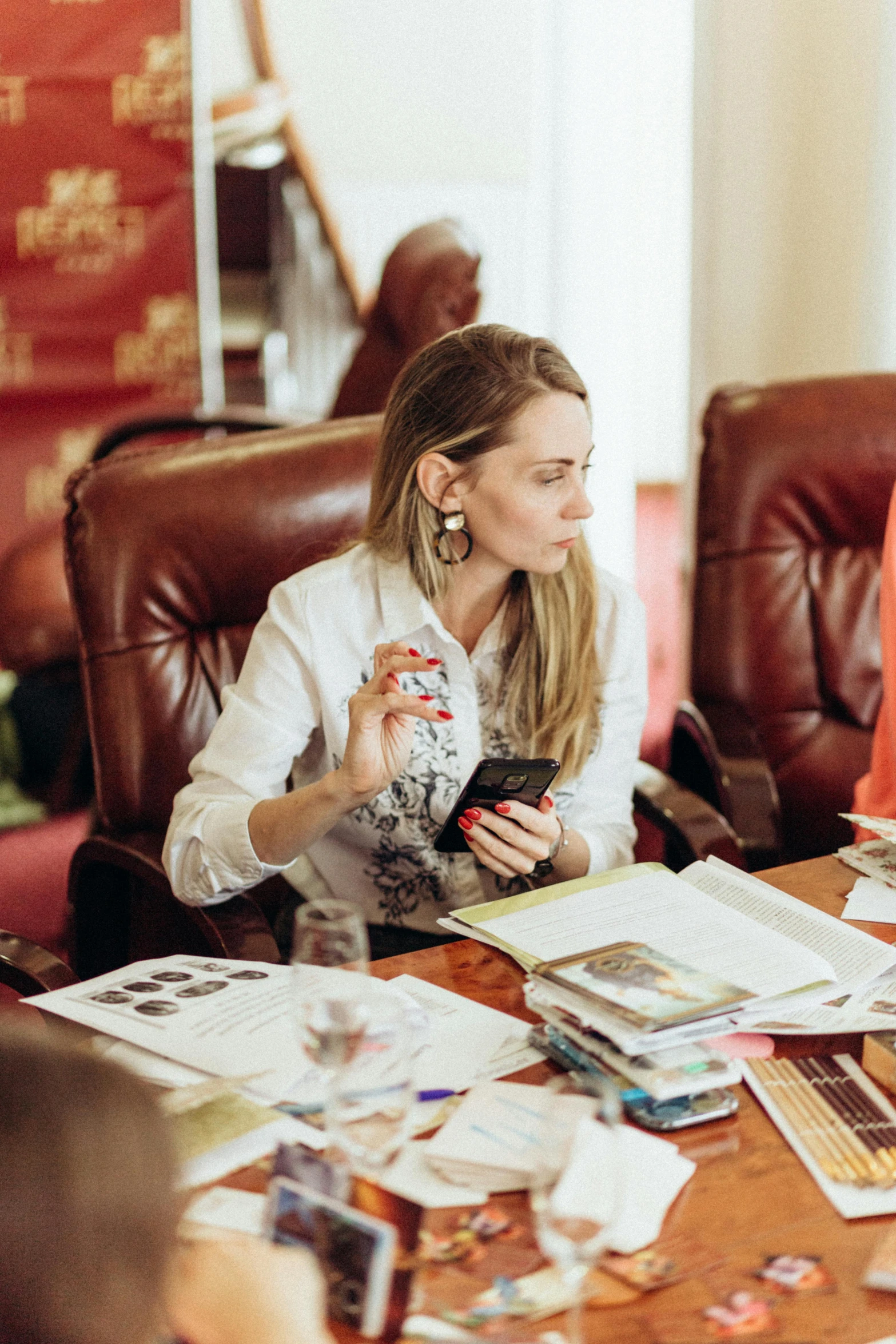 woman sitting at a table with a cell phone