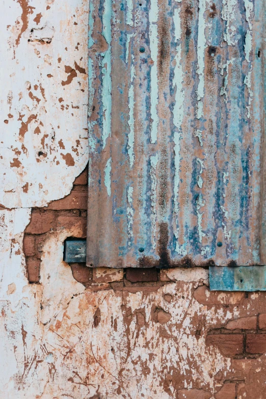 an old wall with peeling paint and a rusty rusted part