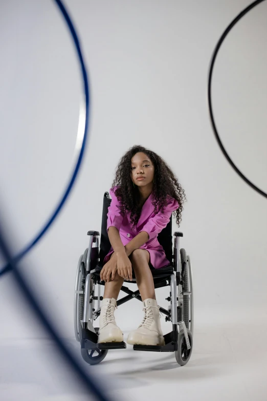 a woman in a pink shirt sitting on a wheelchair