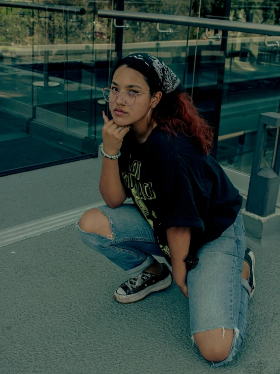 a  sits on the ground near her skateboard