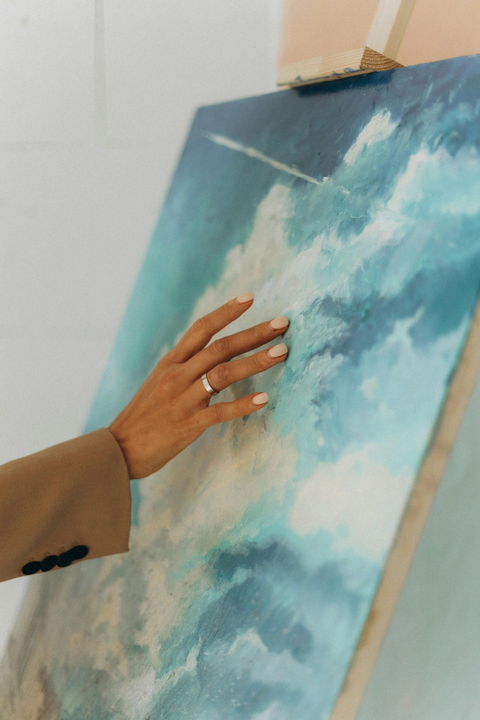 a person's hand on an art canvas