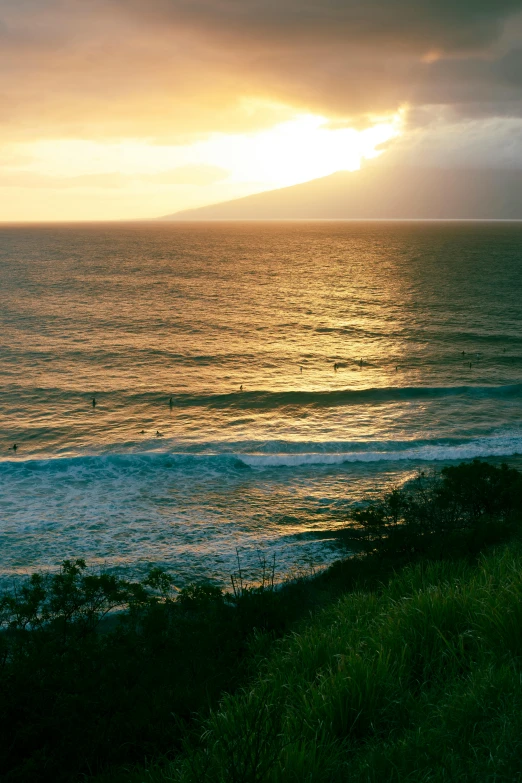 sunset over a beach and ocean with dark clouds