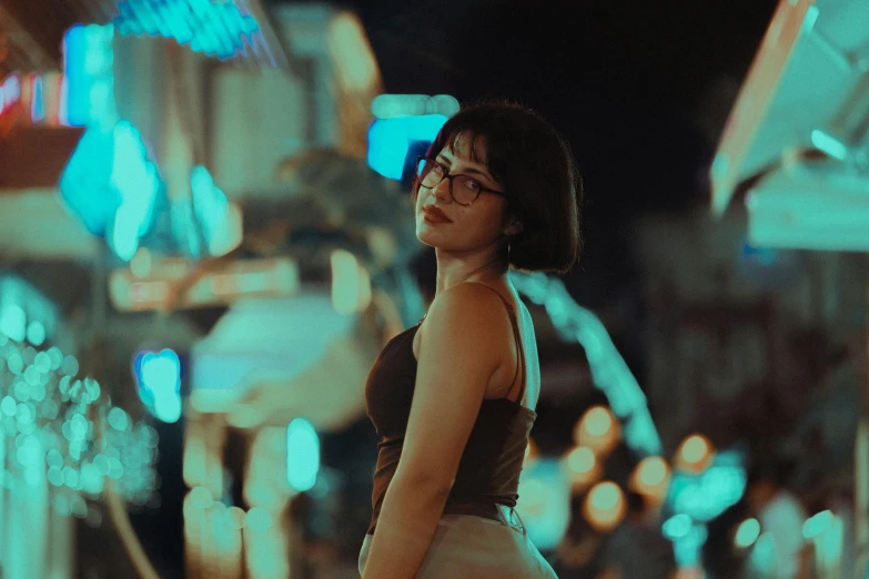 a girl standing at night with buildings in the background