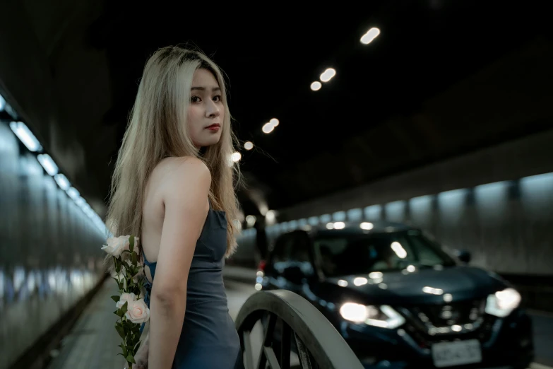 a girl standing in front of a car