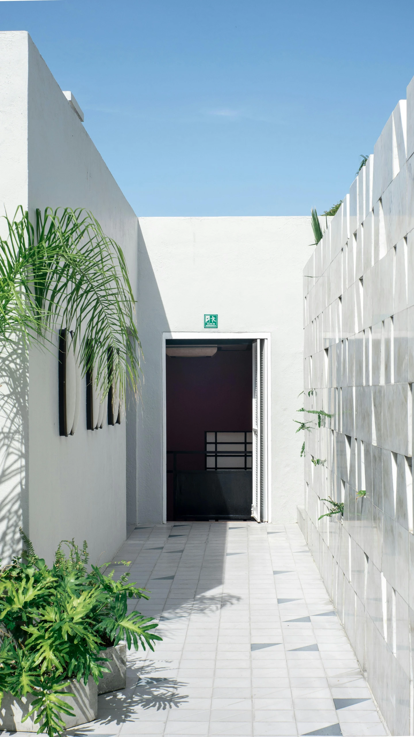 a wall covered in cement is shown with a gate to a small courtyard