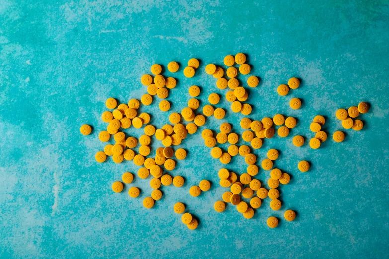 a lot of yellow pills sitting on top of a table