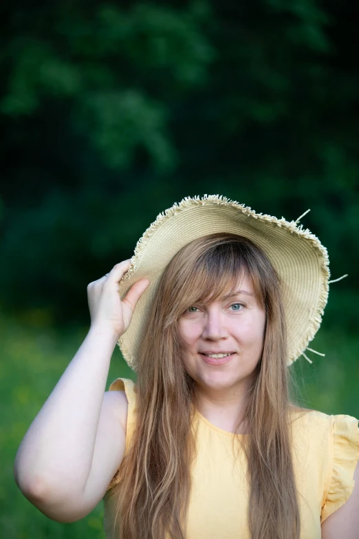 a woman wearing a hat poses for the camera