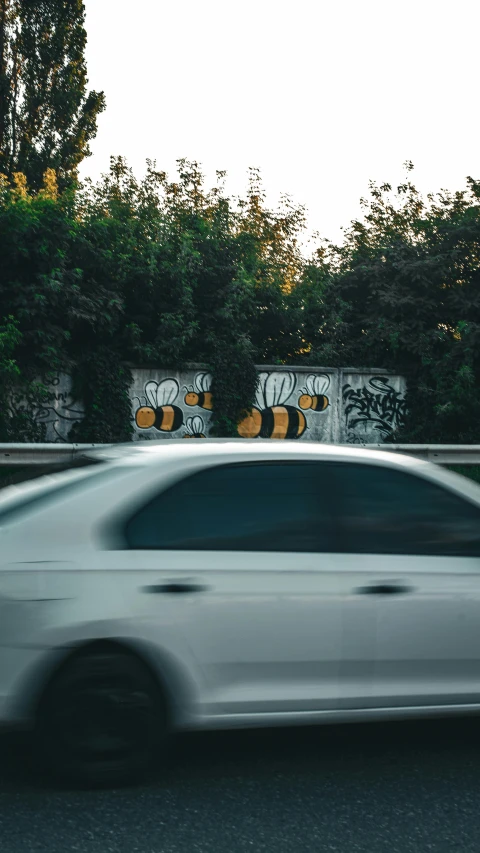 car speeding by graffiti covered gate on busy street