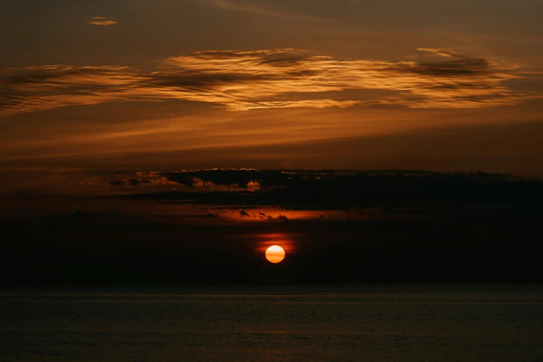 an image of the sun setting over the water