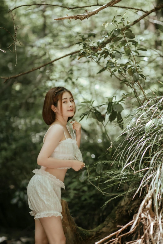 a young lady wearing white lingerie and posing in front of the camera