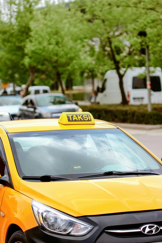 a taxi cab with a yellow sign on top is parked in front of other vehicles