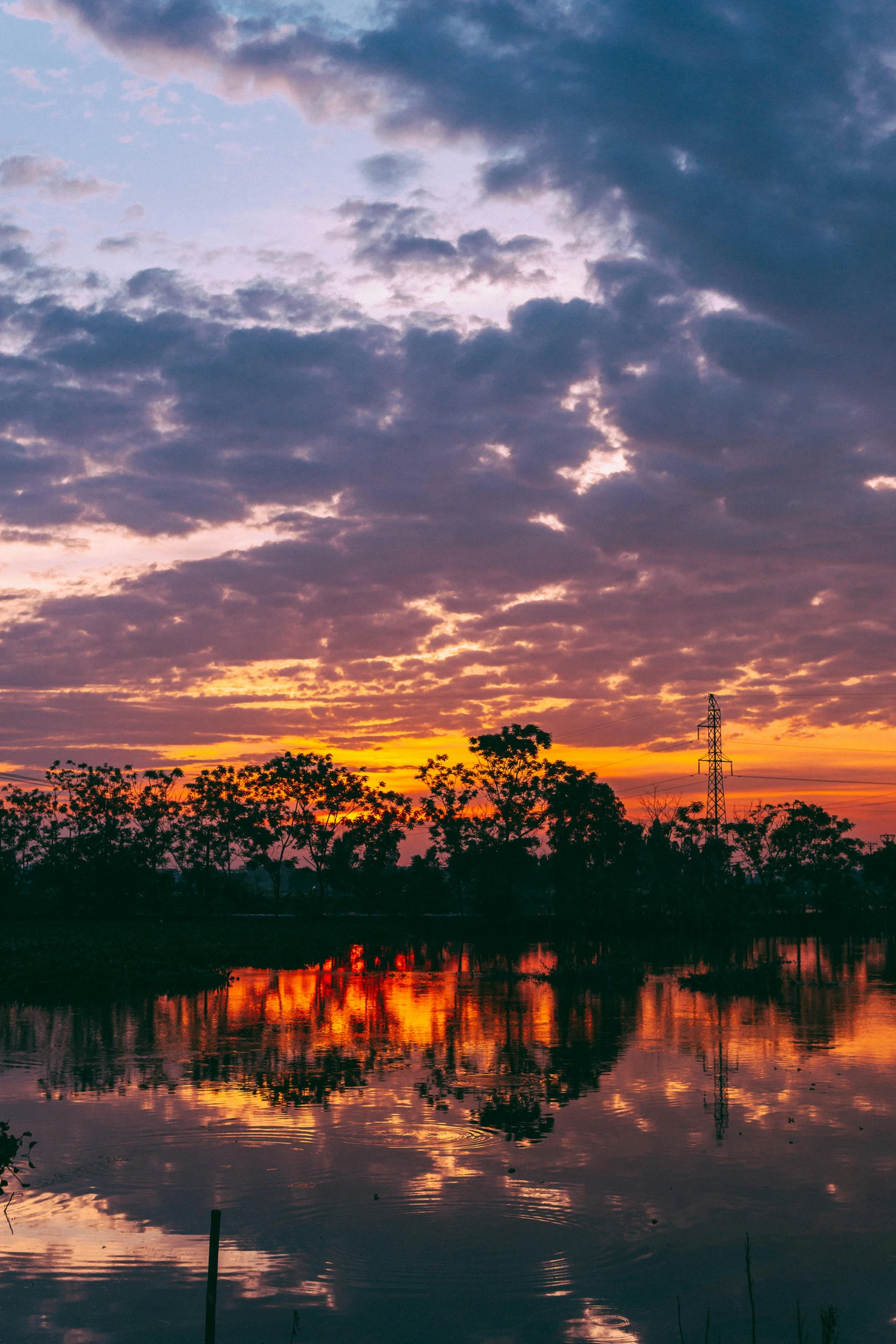 the clouds are flying in the sunset over the water