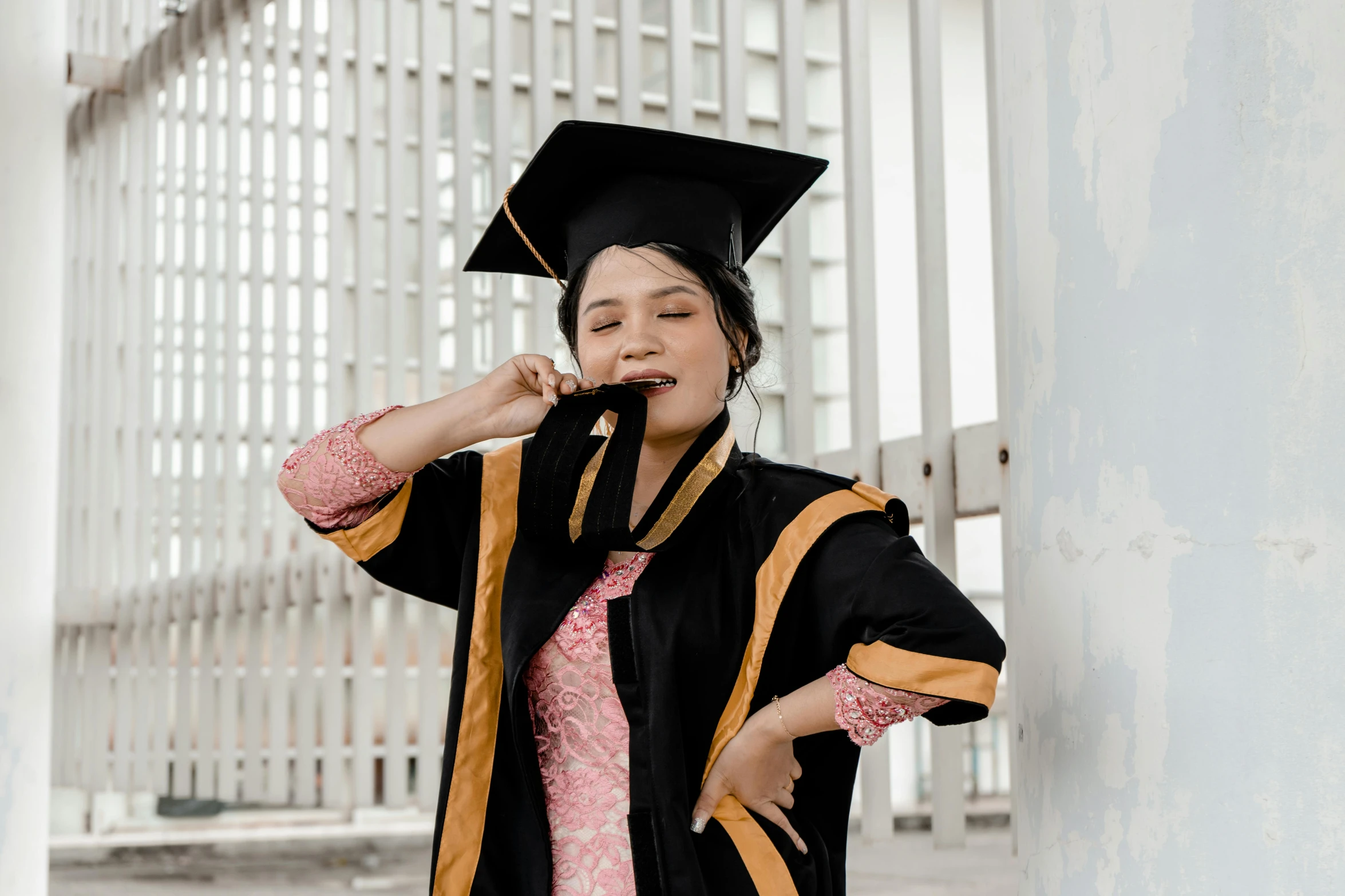 a woman in graduation cap and gown talking on her cell phone