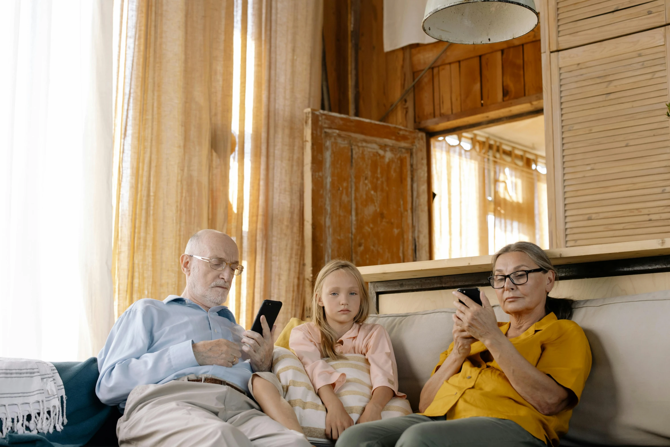 two women and an old man sitting on a couch