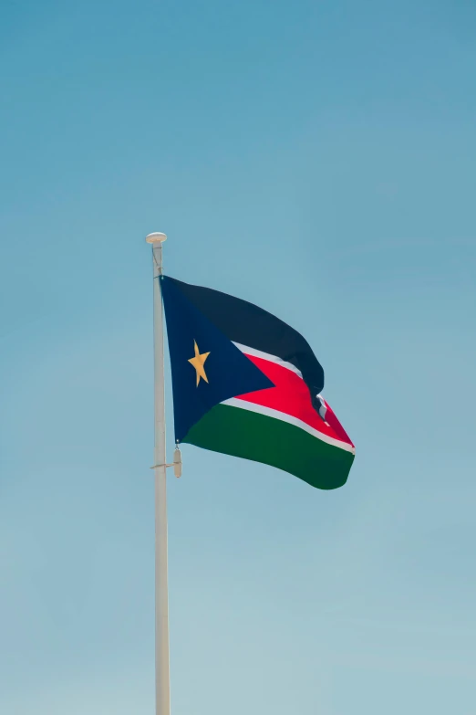 a flag flying with a clear blue sky